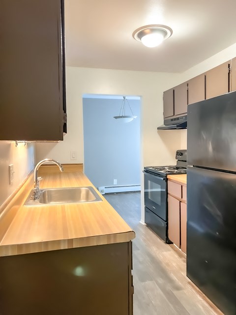 a kitchen with wood countertops and black appliances