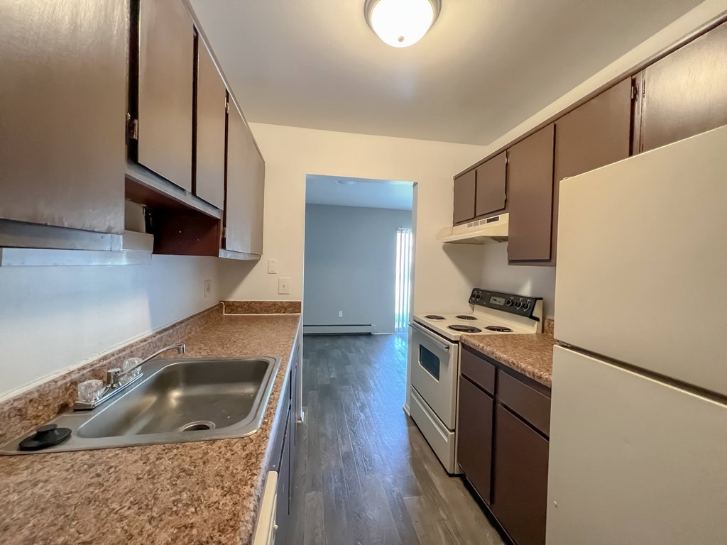 a kitchen with brown cabinets and a white stove top oven