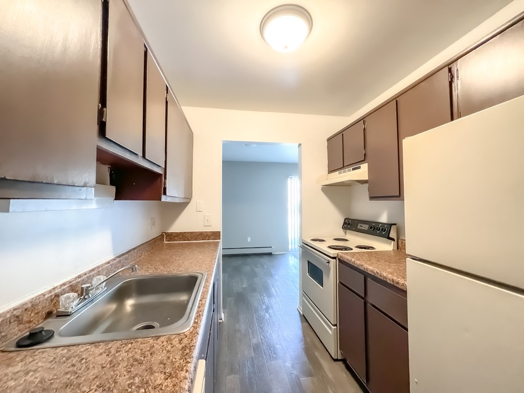 a kitchen with brown cabinets and a white stove top oven