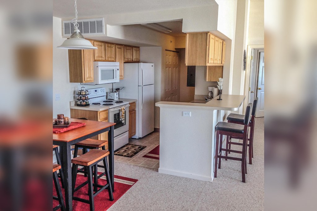 a view of a kitchen and a dining room with a table and chairs
