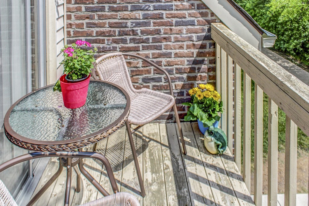 a patio with a table and chairs and flowers on it