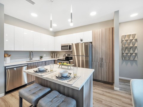 a kitchen with a island and a stainless steel refrigerator