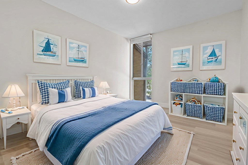 A bedroom with a large bed and a white nightstand.