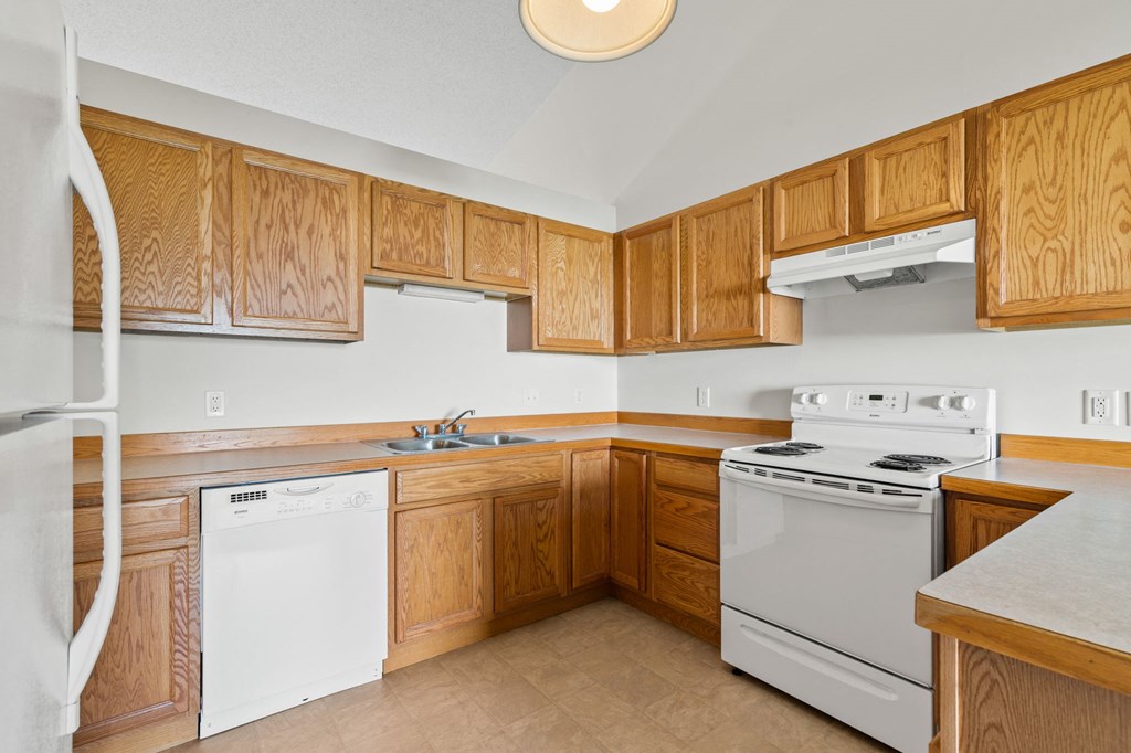 a kitchen with white appliances and wooden cabinets