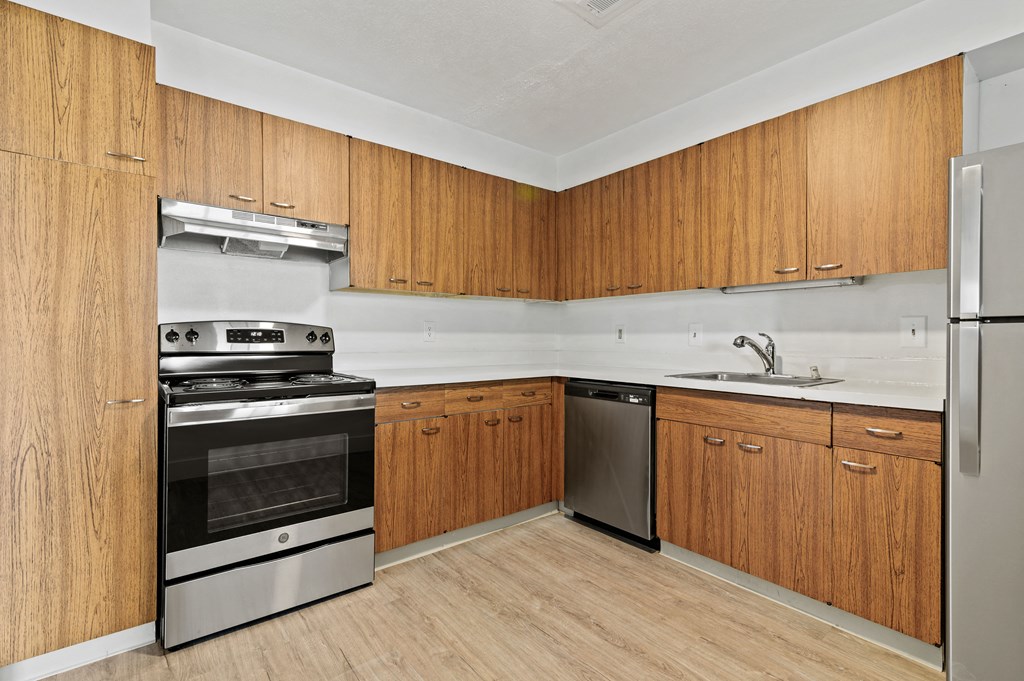 a kitchen with wooden cabinets and stainless steel appliances