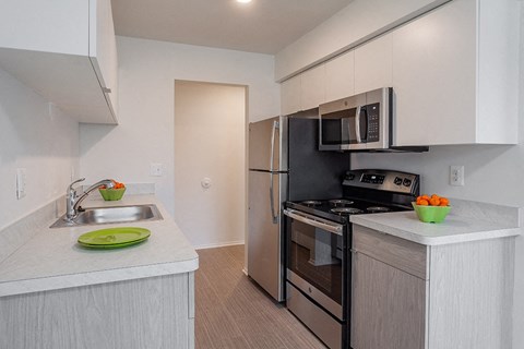 a kitchen with white cabinets and stainless steel appliances