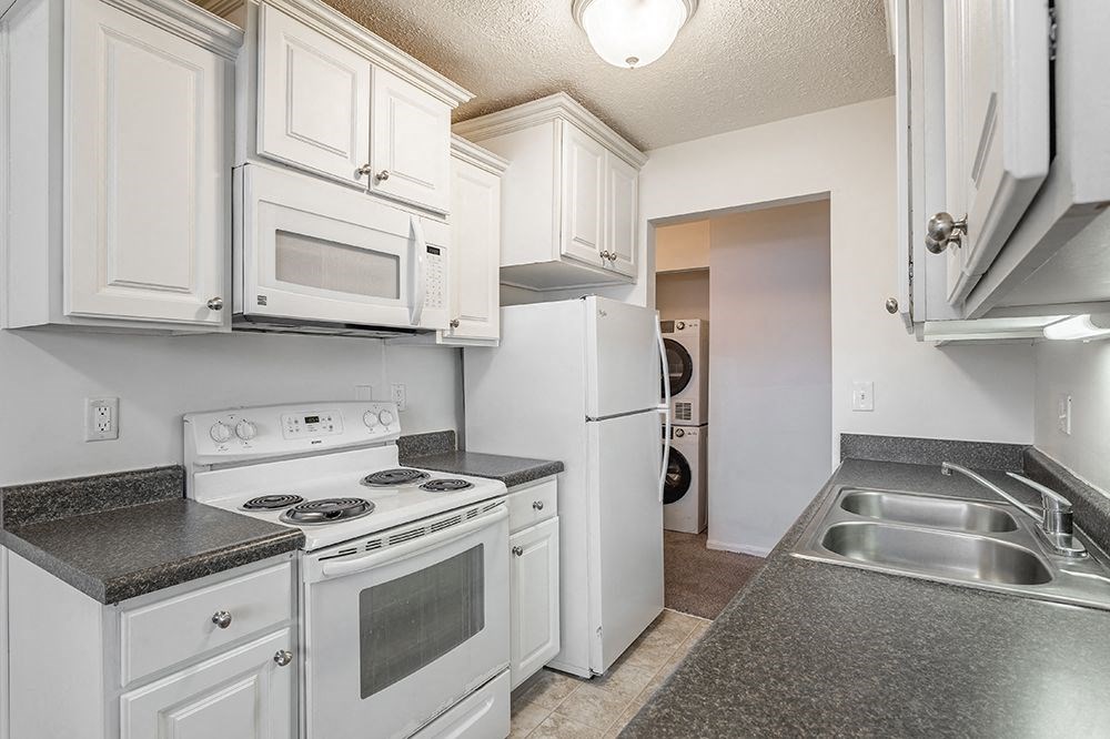 a kitchen with white appliances and white cabinets
