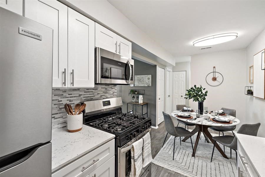 a kitchen and dining room with a stove and microwave