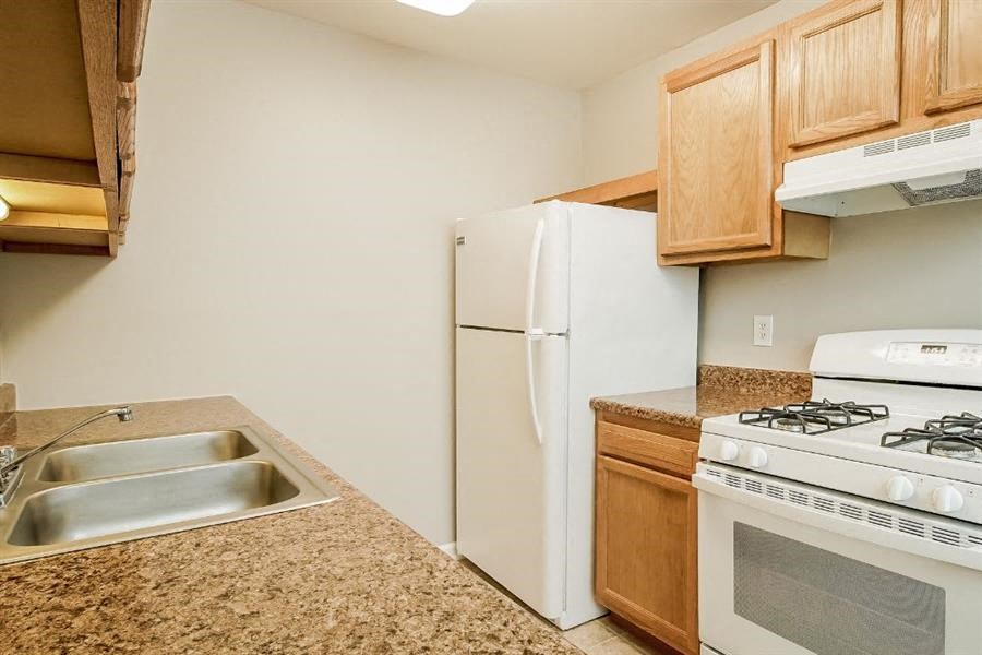 a kitchen with a stove refrigerator and sink