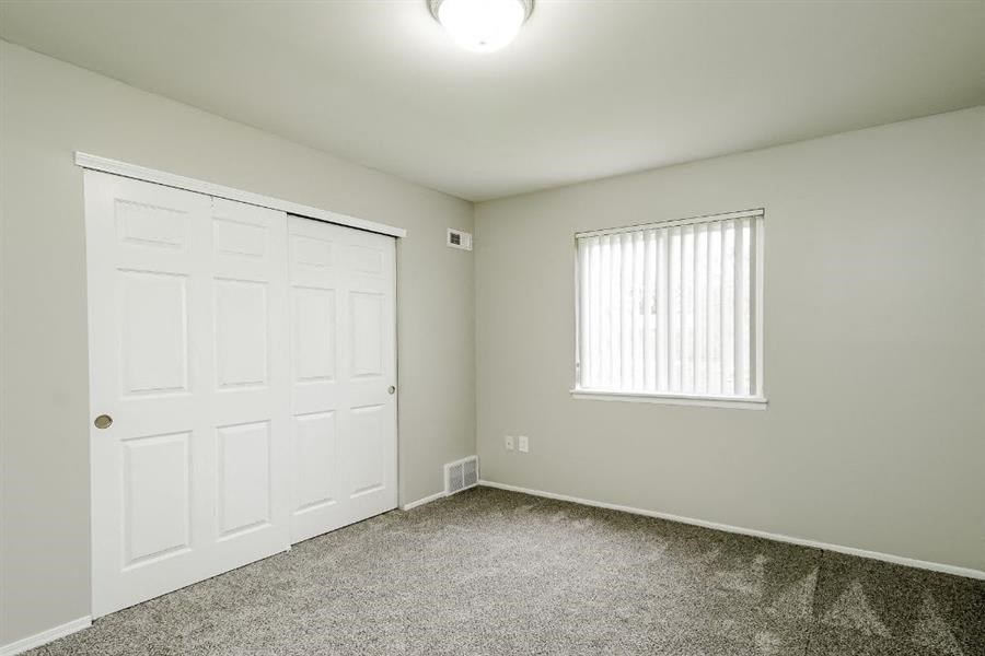 an empty room with a white door and a window