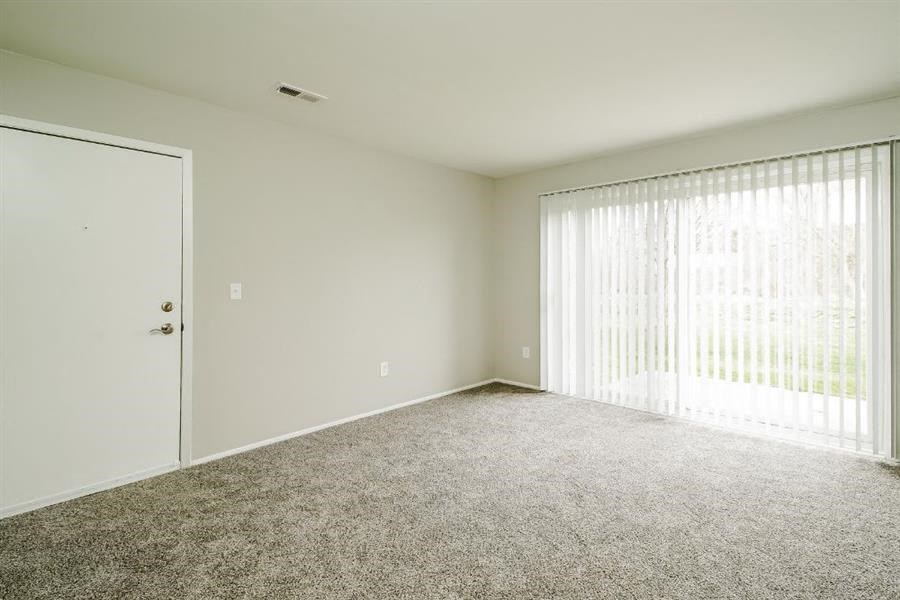 an empty living room with a sliding glass door