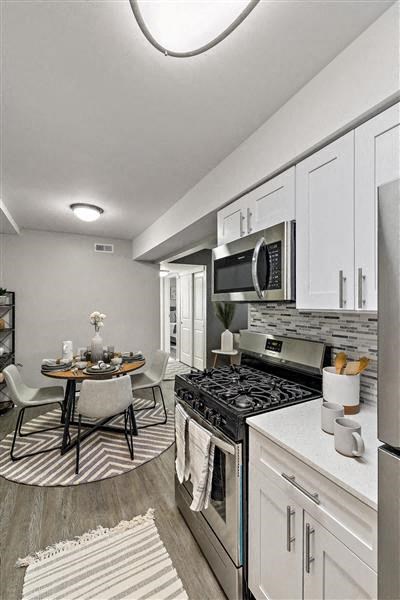 a kitchen with a stove and a microwave and a table