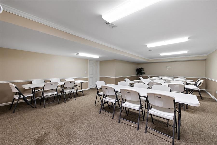 a room filled with white tables and chairs