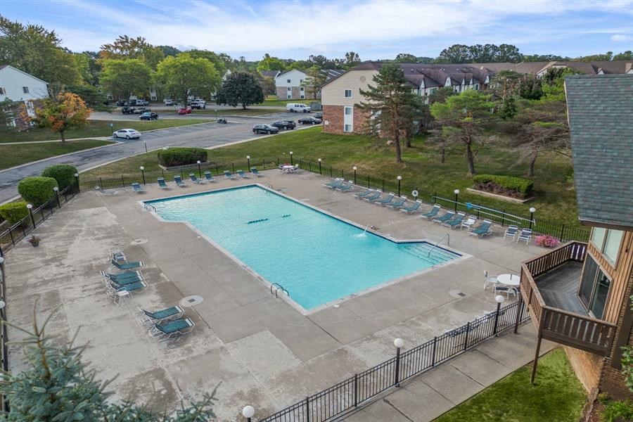 an aerial view of a swimming pool with chairs