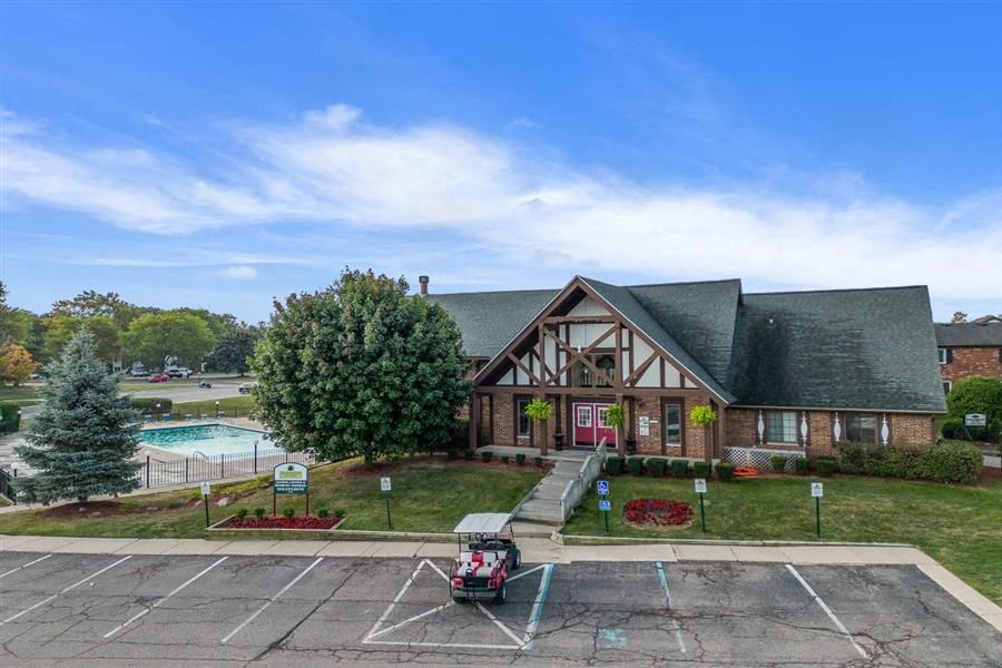 a house with a driveway and a pool in front of it