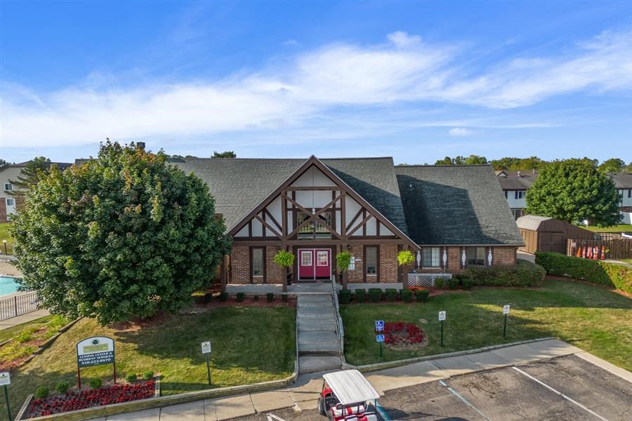 the front of a house with a yard and a tree