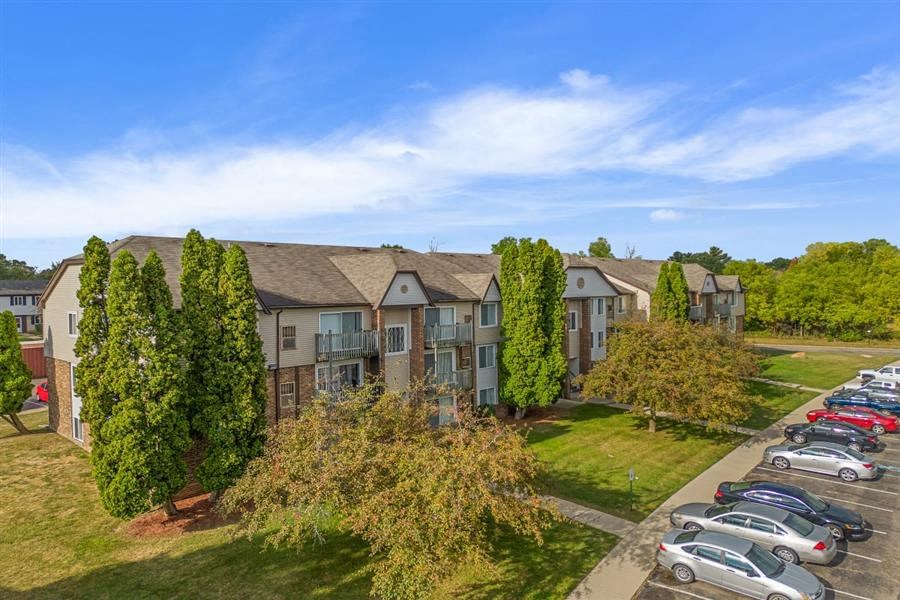 an aerial view of an apartment building with a parking lot