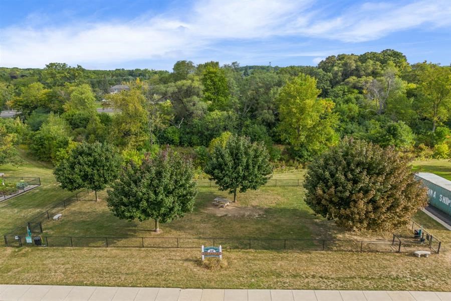an aerial view of a park with trees and a fence