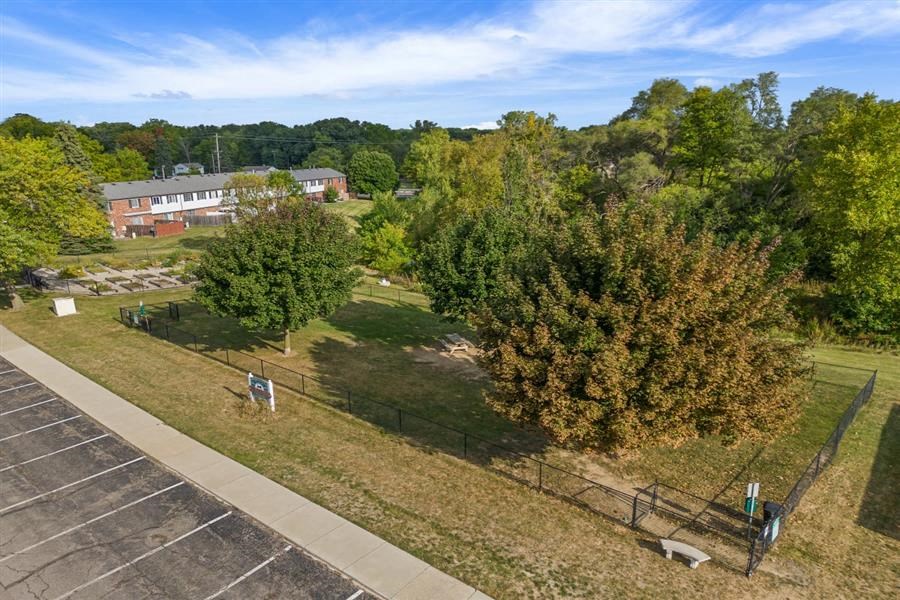 an aerial view of a park with trees and a fence