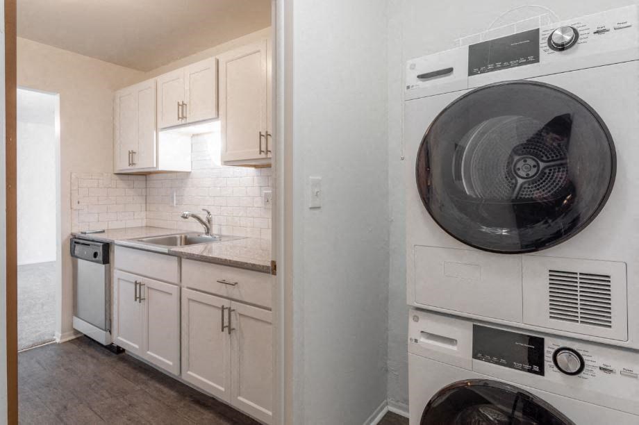 a white kitchen with a washer and dryer