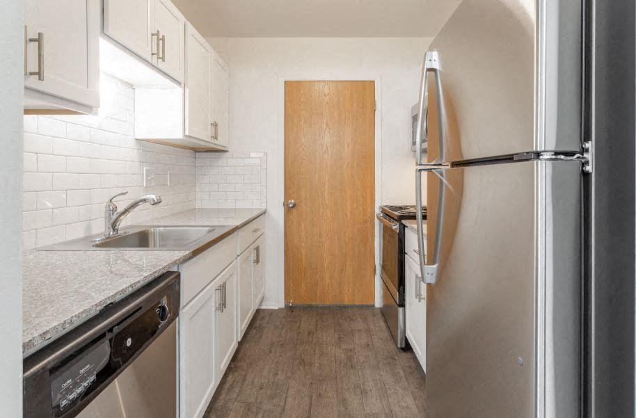 a small kitchen with white cabinets and stainless steel appliances