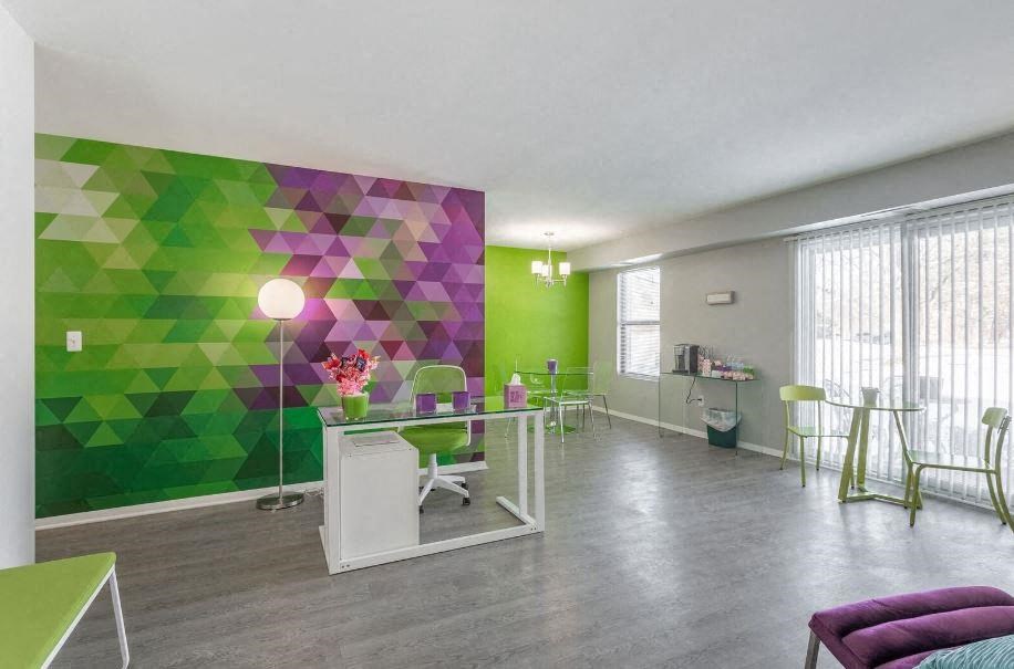 a room with a green and purple wall and a table and chairs