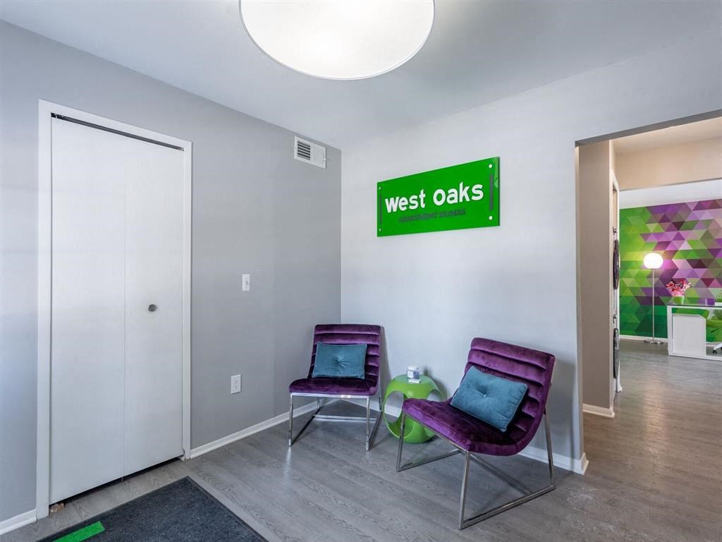 a room with two purple chairs and a green sign on the wall