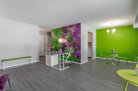 a living room with a green wall and a table and chairs
