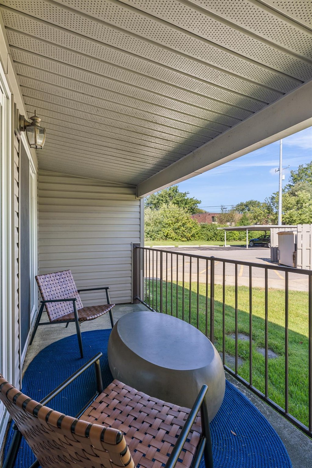 a patio with two chairs and a table on a balcony at Sunnymede Apartments - Troy, MI, Troy, 48084