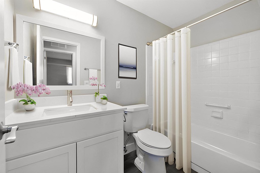 a bathroom with a toilet sink and a shower at Sunnymede Apartments - Troy, MI, Michigan