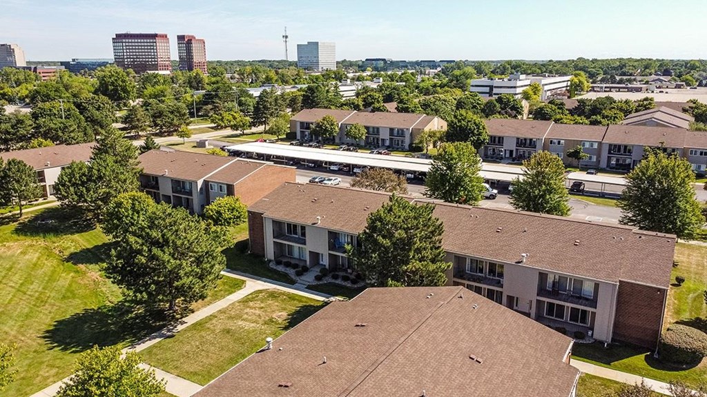 an aerial view of houses in a neighborhood with a city in the background at Sunnymede Apartments - Troy, MI, Troy