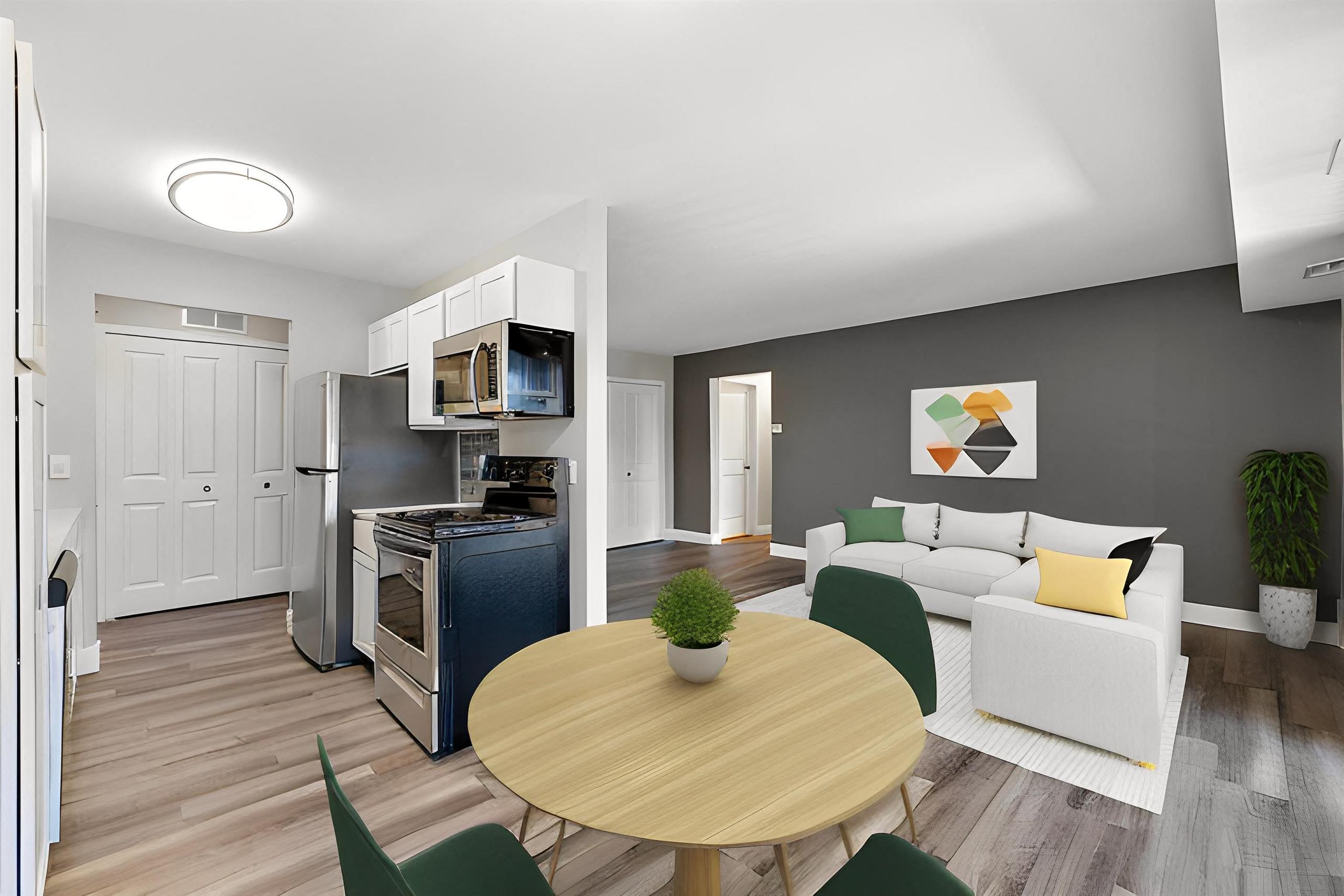 a living room and dining room with a table and chairs at Sunnymede Apartments - Troy, MI, Troy, 48084