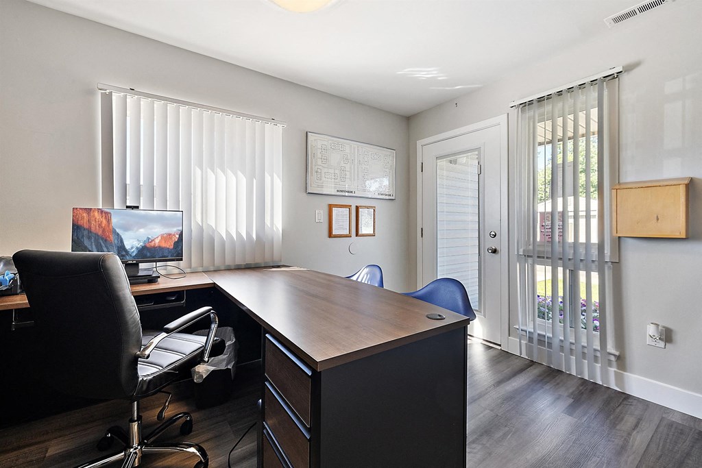 a home office with a desk and a window with blinds at Sunnymede Apartments - Troy, MI, Michigan