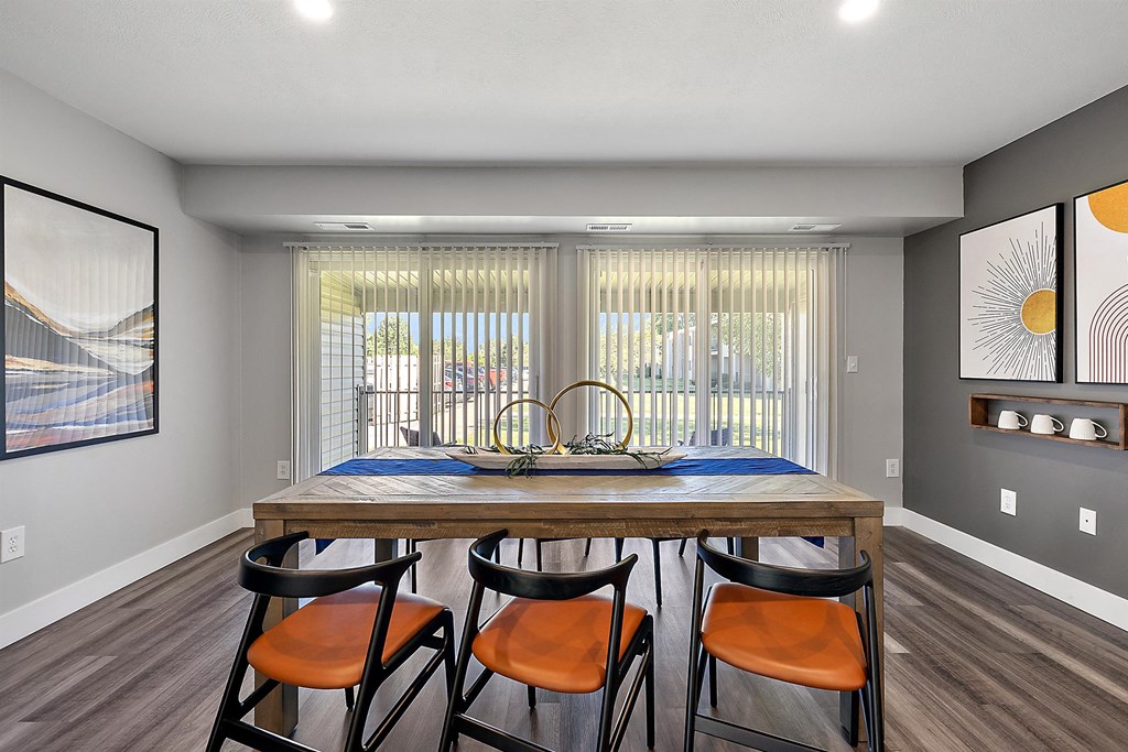 a dining room with a wooden table and four chairs at Sunnymede Apartments - Troy, MI, Troy, Michigan