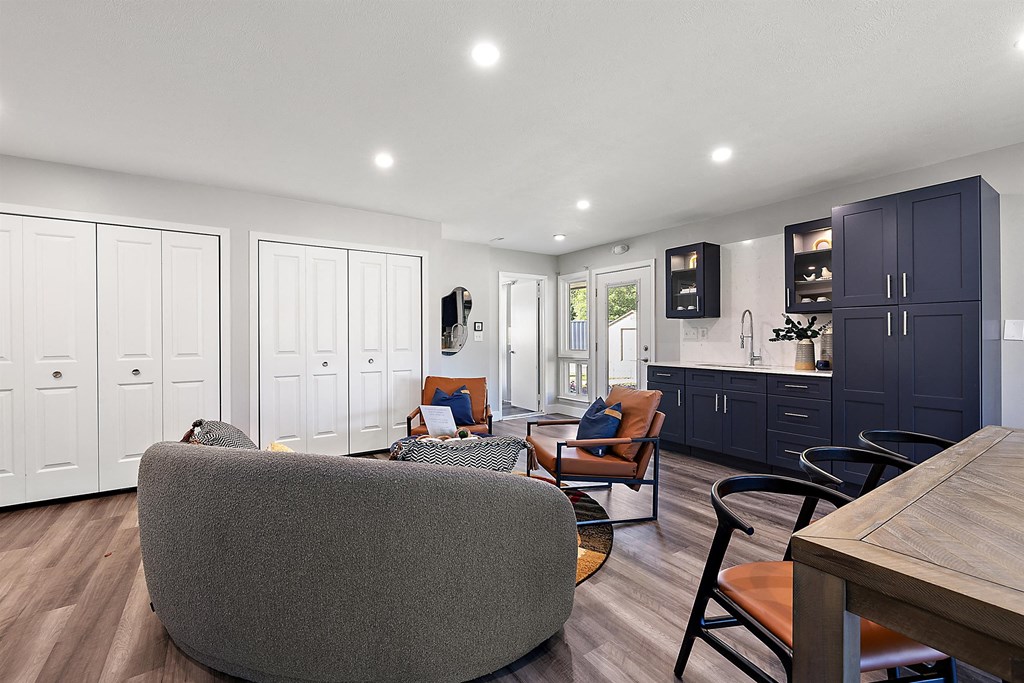 a living room with a kitchen and a table and chairs at Sunnymede Apartments - Troy, MI, Troy, 48084