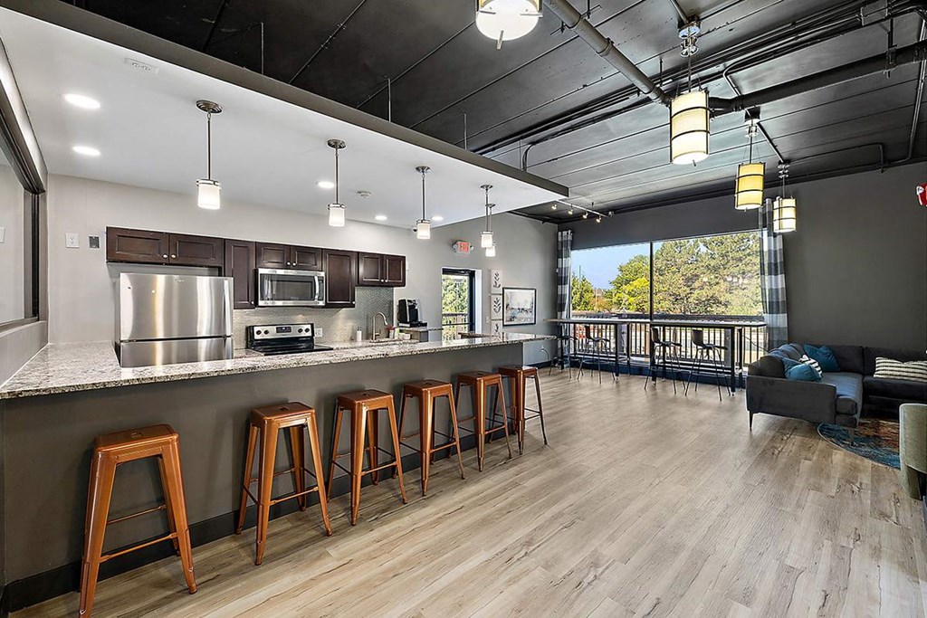 a kitchen with a bar and stools at Troy Place Apartments - Troy, MI, Michigan