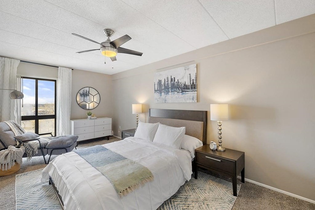 a bedroom with a bed and a ceiling fan at Troy Place Apartments - Troy, MI, Troy