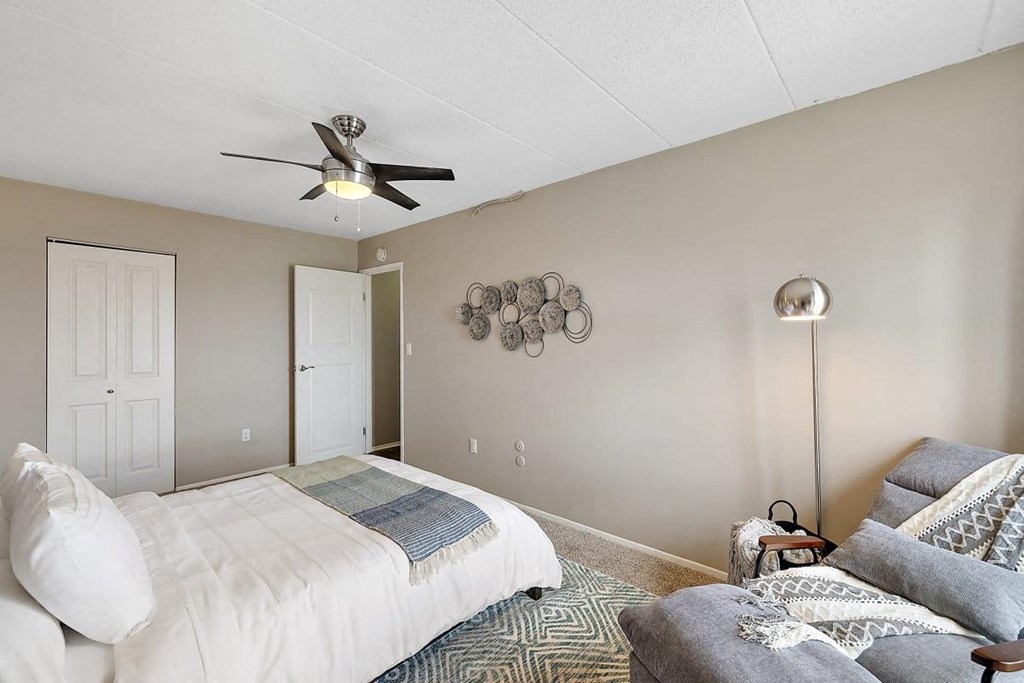 a bedroom with a bed and a ceiling fan at Troy Place Apartments - Troy, MI, Troy