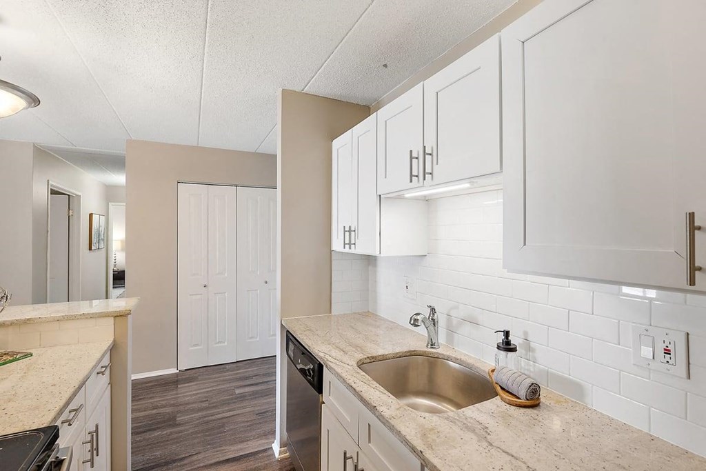 a kitchen with white cabinets and a sink at Troy Place Apartments - Troy, MI, Michigan
