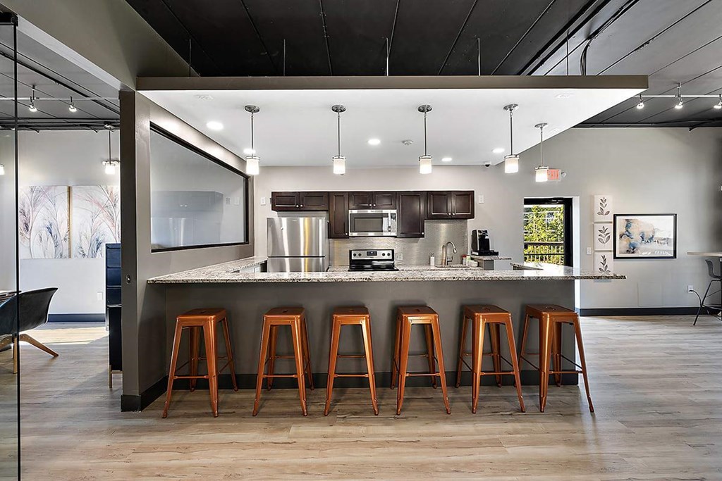 a kitchen with a counter and bar stools at Troy Place Apartments - Troy, MI, Troy