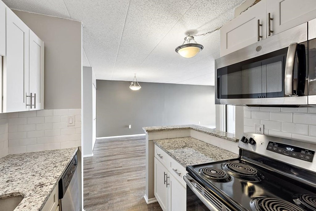the interior of a building with white and gray striped walls and a staircase at Troy Place Apartments - Troy, MI, Michigan
