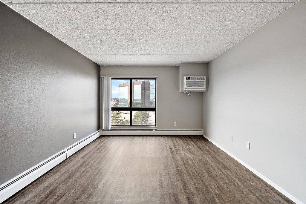an empty room with a window and wood floors at Troy Place Apartments - Troy, MI, Troy, 48084