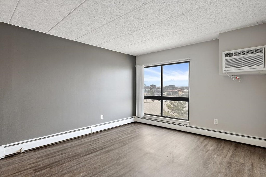 living room with a large window and wood floors at Troy Place Apartments - Troy, MI, Troy, Michigan
