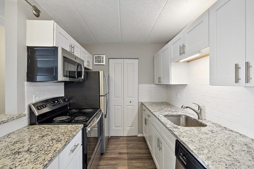 kitchen with white cabinets and granite counter tops at Troy Place Apartments - Troy, MI, Troy, 48084
