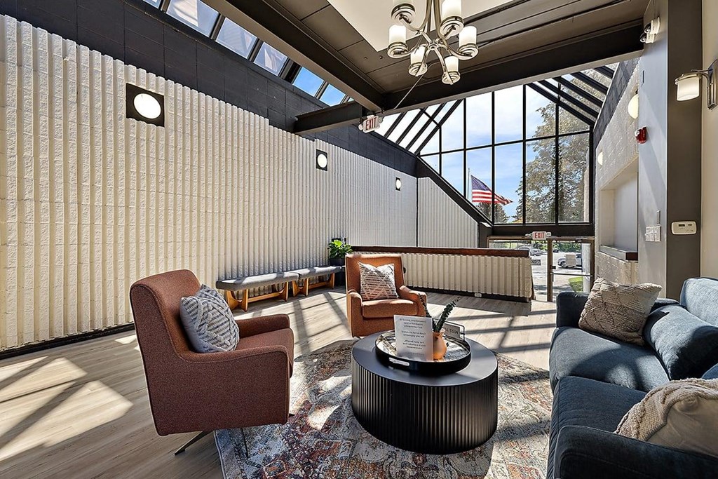 a living room with couches and chairs and a table at Troy Place Apartments - Troy, MI, Troy, Michigan