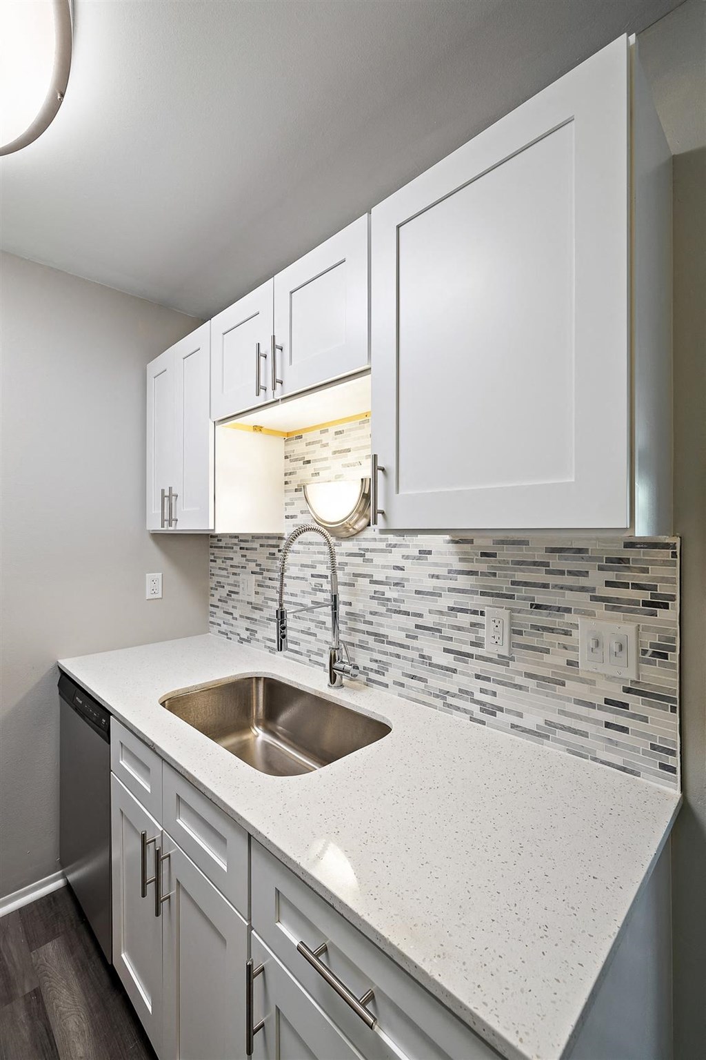 a kitchen with white cabinets and a sink at Town & Country Apartments - Wixom, MI, Wixom