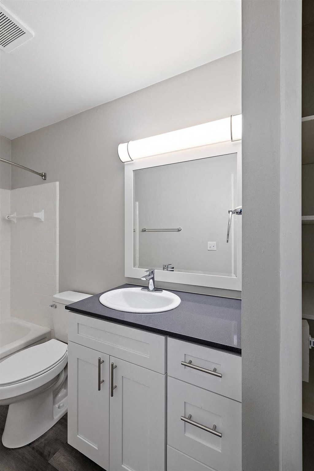 a white bathroom with a sink and a toilet at Town & Country Apartments - Wixom, MI, Michigan