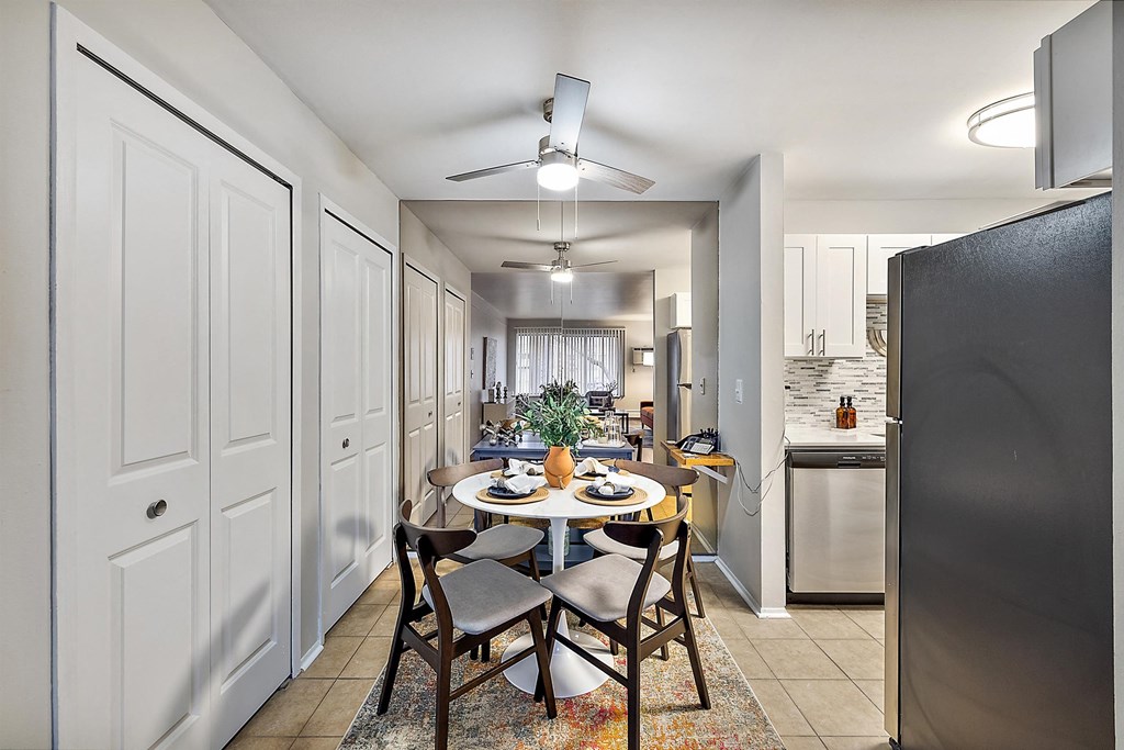 an open kitchen and dining room with a table and chairs at Town & Country Apartments - Wixom, MI, Wixom