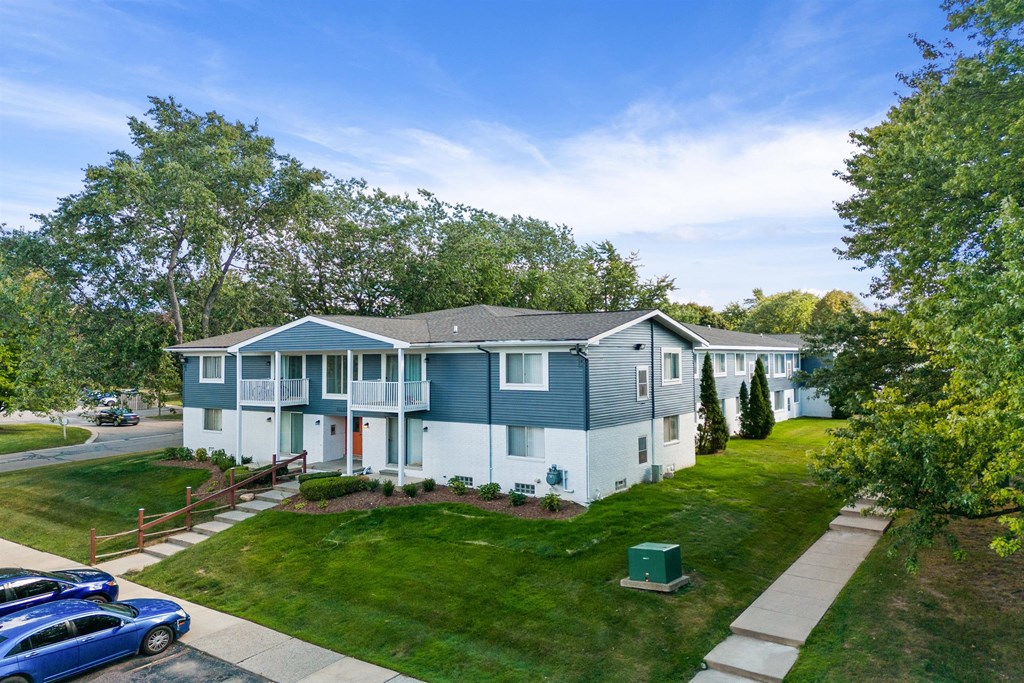 a blue and with cars parked in front of it at Town & Country Apartments - Wixom, MI, Wixom, Michigan