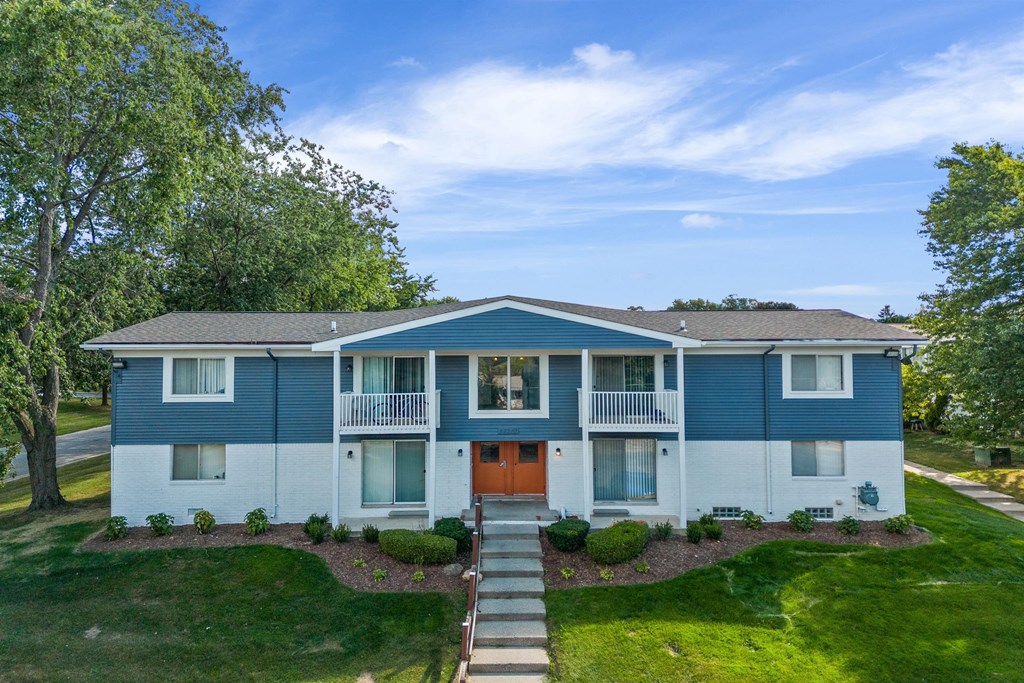 the view of a blue and white house with a orange door at Town & Country Apartments - Wixom, MI, Wixom